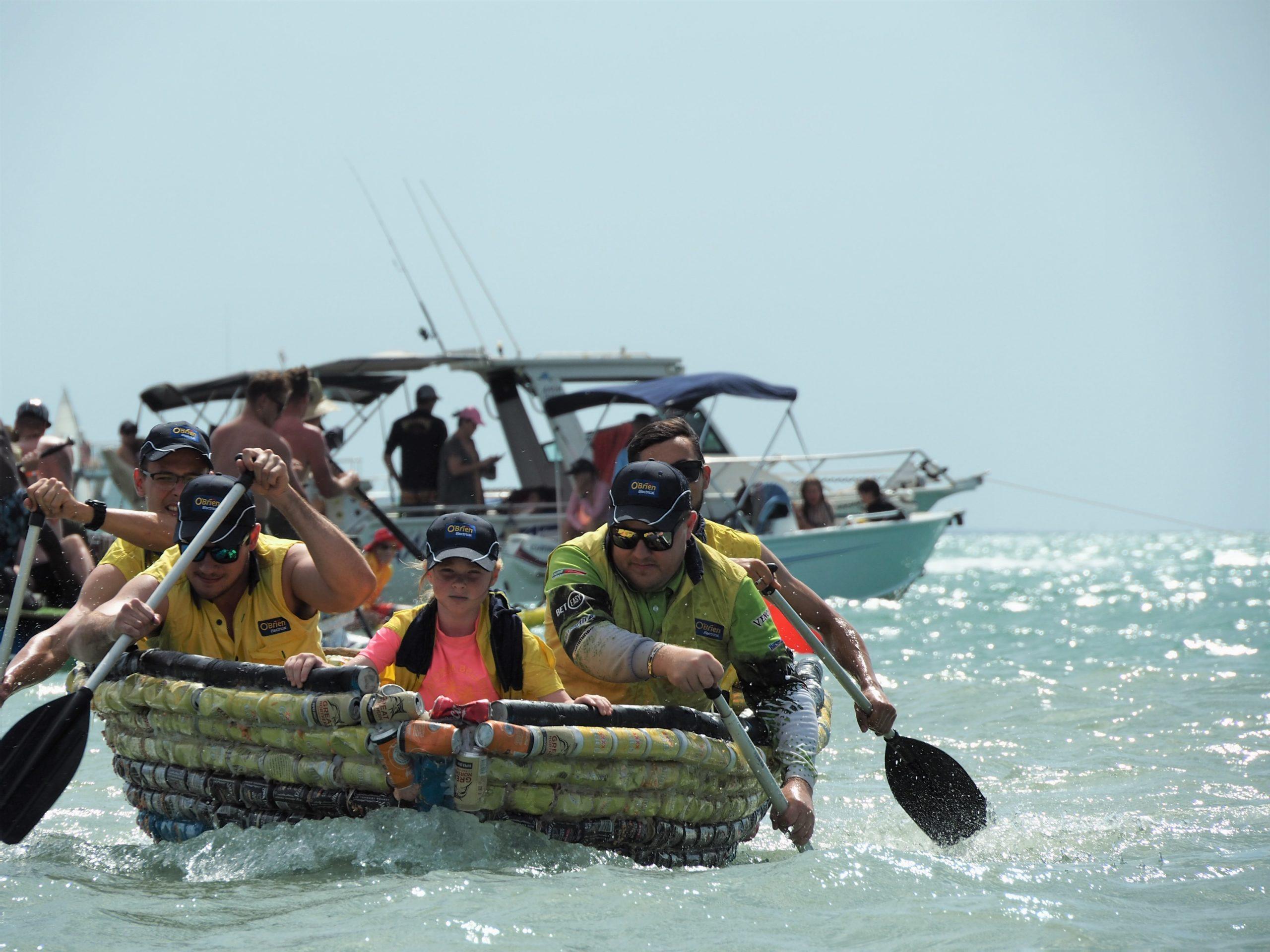 People rowing in a raft made of beer cans