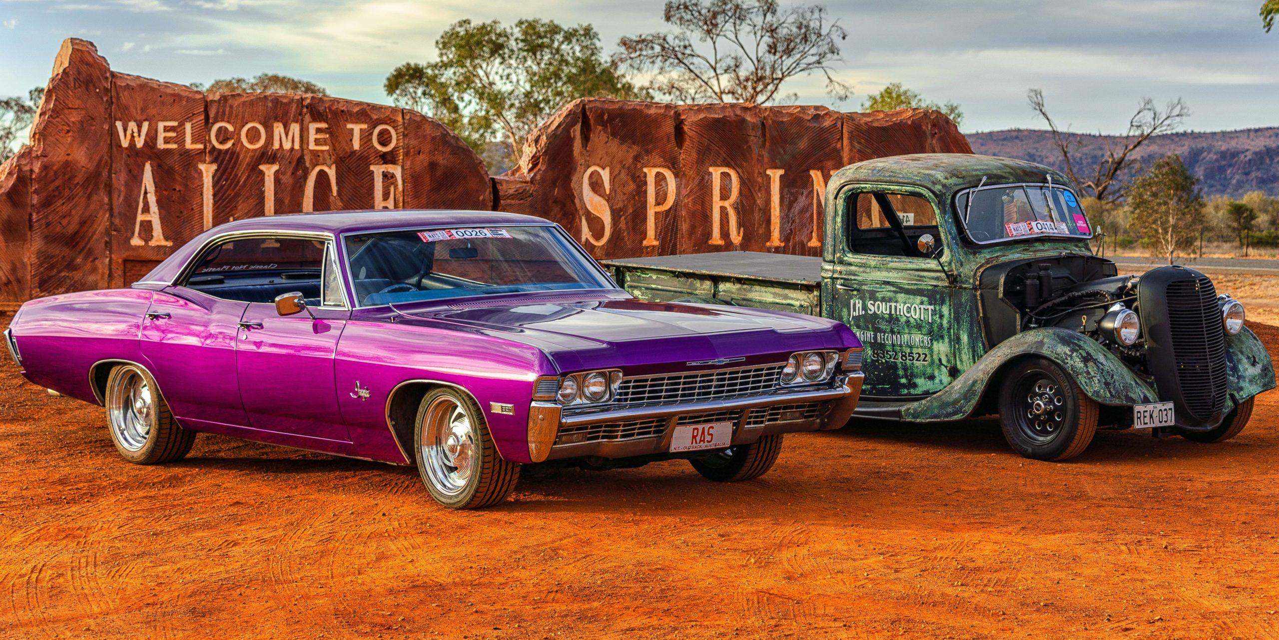 Red CentreNATS cars in front of the Alice Springs sign