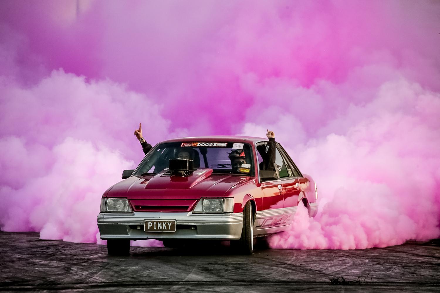 Sedan doing a burnout with pink smoke